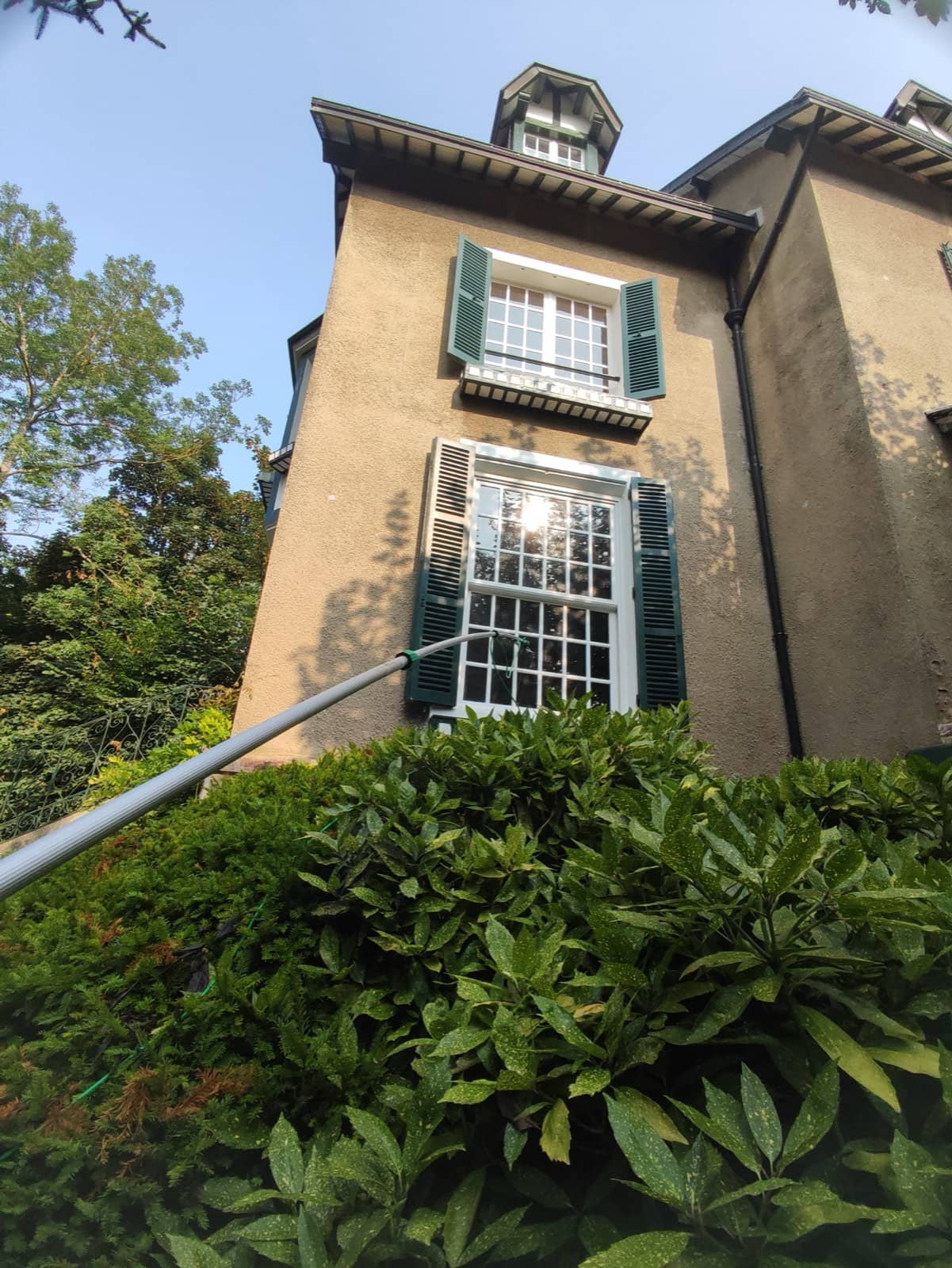 Nettoyage de vitres à la perche télescopique sur une maison dans les Yvelines